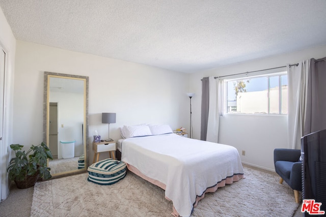 carpeted bedroom featuring a textured ceiling