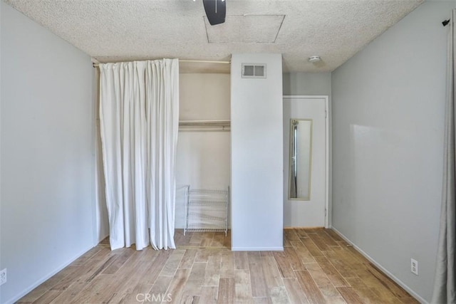 unfurnished bedroom with a textured ceiling, a closet, and ceiling fan