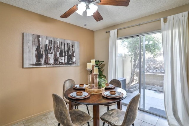 tiled dining room featuring a textured ceiling and ceiling fan