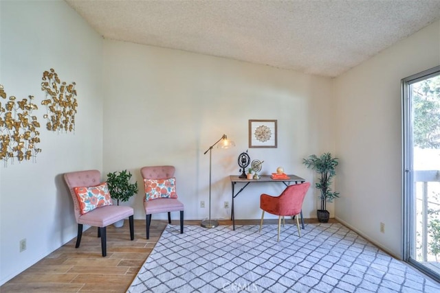 living area with light wood-type flooring and a textured ceiling