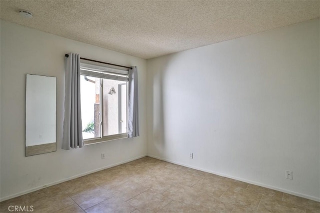 unfurnished room with a textured ceiling