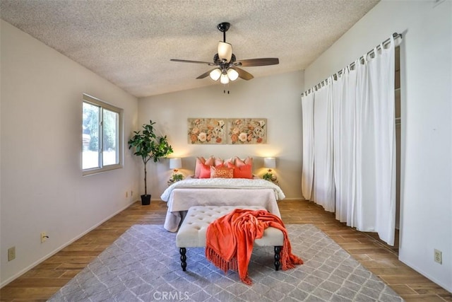 bedroom featuring ceiling fan, wood-type flooring, and a textured ceiling