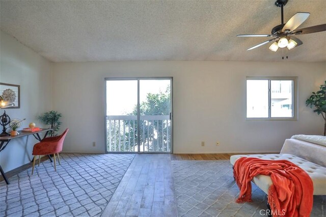 interior space featuring ceiling fan, hardwood / wood-style floors, and a textured ceiling