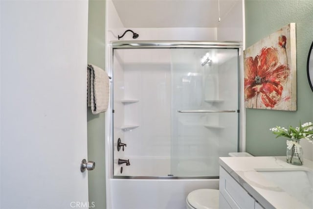 full bathroom featuring vanity, bath / shower combo with glass door, and toilet