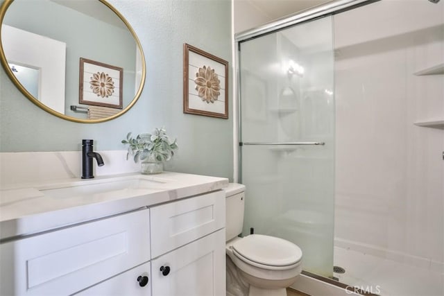 bathroom featuring vanity, toilet, and an enclosed shower