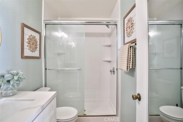 bathroom with vanity, toilet, and a shower with shower door