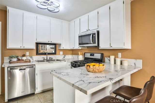 kitchen with kitchen peninsula, white cabinetry, and appliances with stainless steel finishes