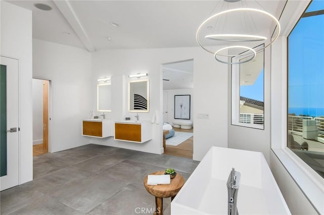 full bathroom featuring a sink, a bathtub, a chandelier, and double vanity