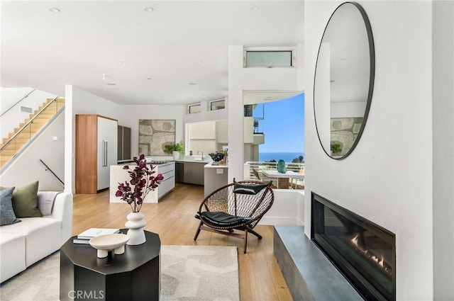living room with a glass covered fireplace and light wood-style floors