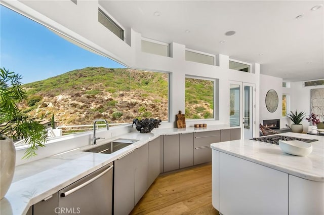 view of patio / terrace with outdoor wet bar, an outdoor kitchen, a sink, and a mountain view