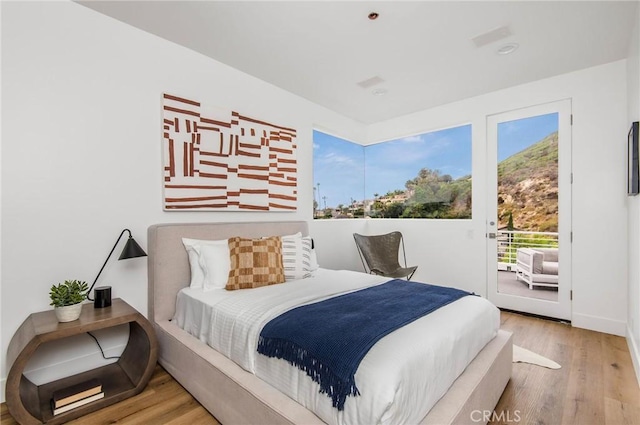 bedroom featuring wood finished floors and access to outside