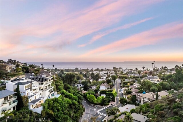 aerial view at dusk featuring a water view