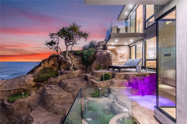 view of patio / terrace with a water view and a balcony