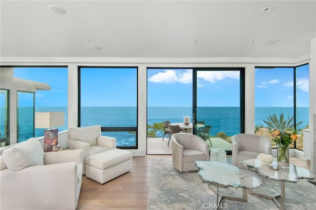 sunroom / solarium with a water view and a healthy amount of sunlight