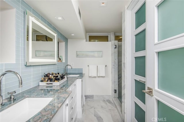 full bathroom with a shower stall, marble finish floor, a sink, and decorative backsplash