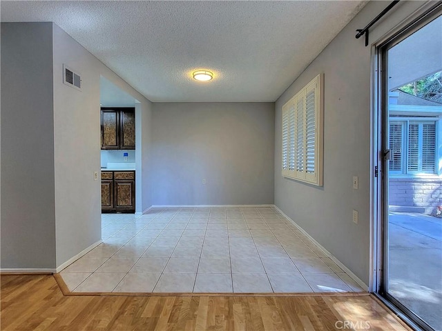 empty room featuring light hardwood / wood-style floors and a textured ceiling