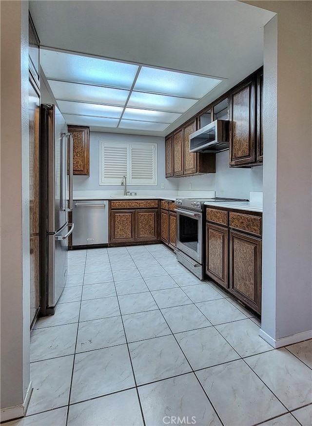 kitchen with sink, light tile patterned flooring, stainless steel appliances, and extractor fan