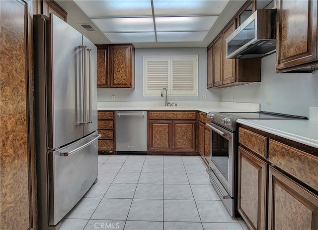 kitchen featuring appliances with stainless steel finishes, light tile patterned floors, and sink