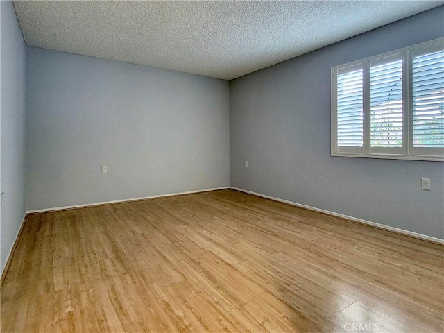 empty room featuring light hardwood / wood-style floors and a textured ceiling