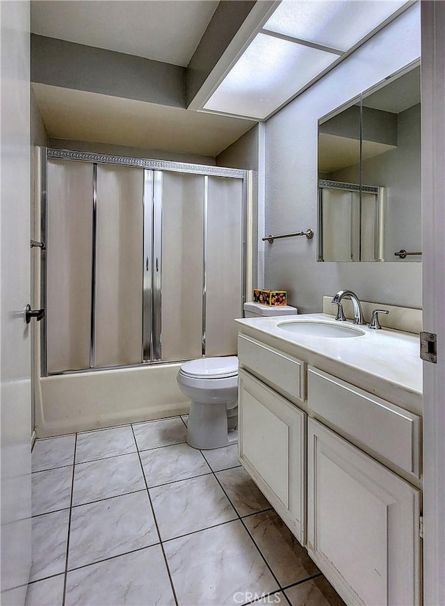 full bathroom featuring tile patterned floors, vanity, toilet, and combined bath / shower with glass door