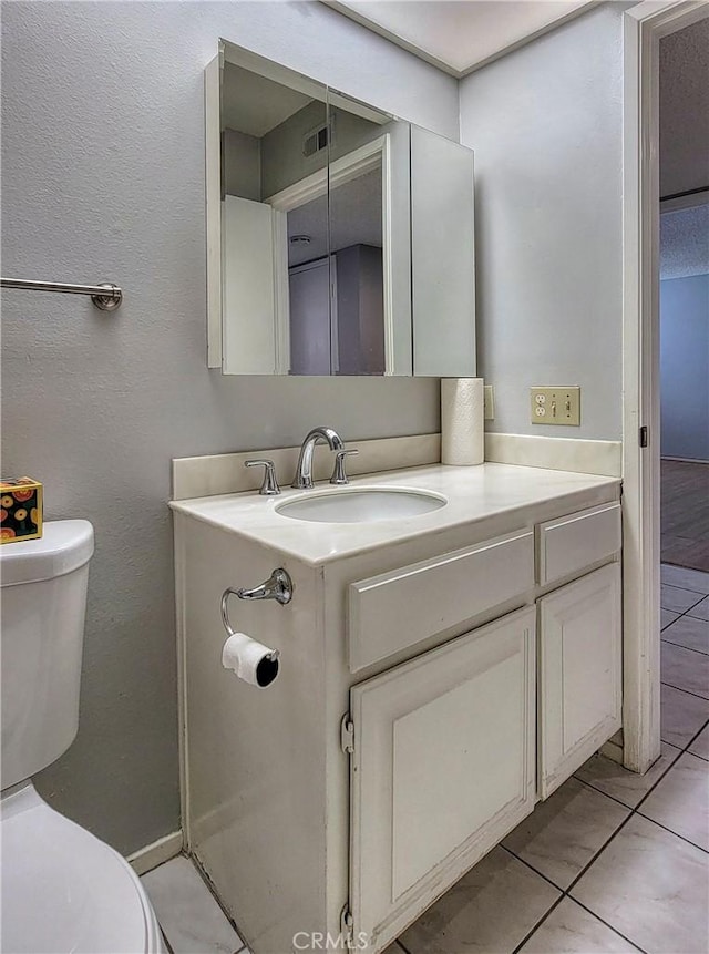 bathroom featuring tile patterned flooring, vanity, and toilet