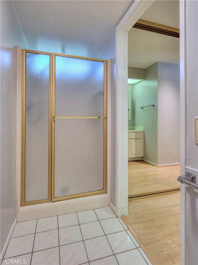 bathroom with tile patterned flooring, vanity, and an enclosed shower