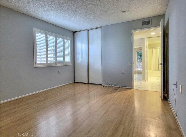 unfurnished bedroom featuring light hardwood / wood-style floors and a textured ceiling