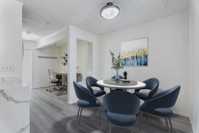 dining space with hardwood / wood-style floors and ornamental molding