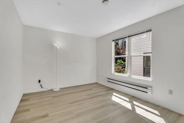 empty room with light wood-type flooring and baseboard heating