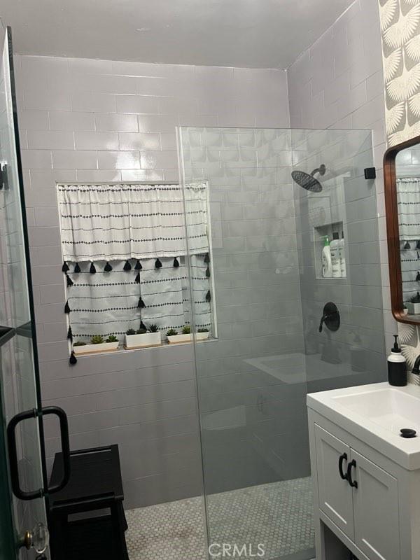 bathroom featuring an enclosed shower and vanity