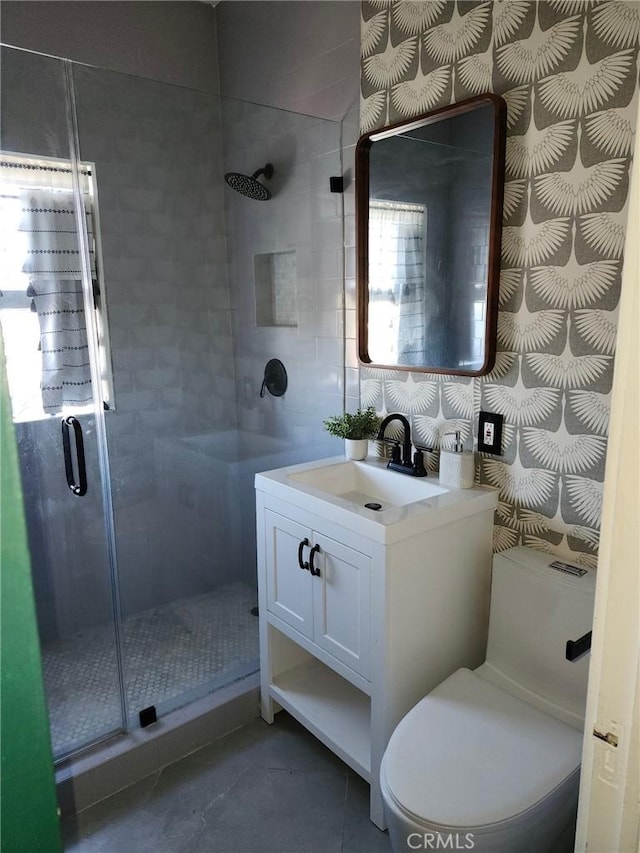 bathroom featuring toilet, vanity, tile patterned flooring, and an enclosed shower