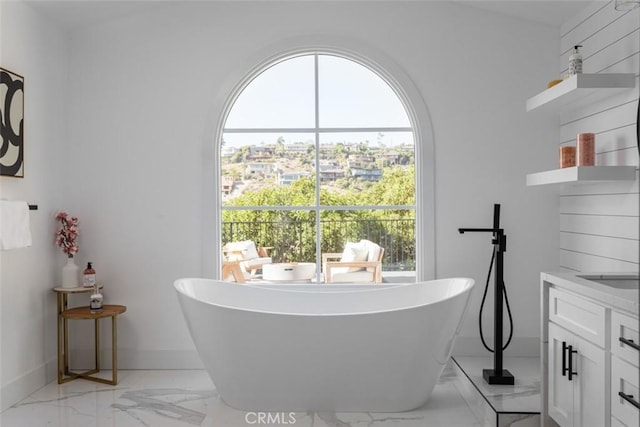 bathroom with plenty of natural light, vanity, and a bath