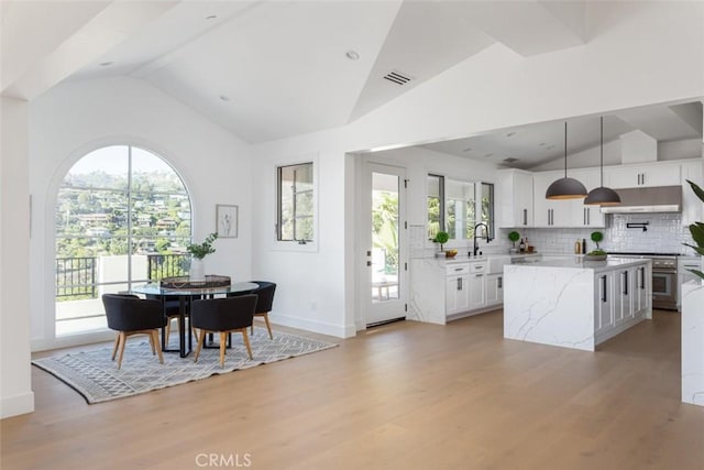 kitchen featuring pendant lighting, a center island, white cabinetry, and a wealth of natural light