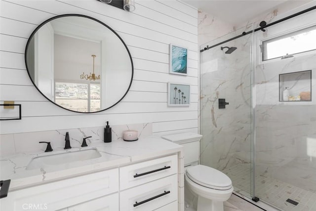 bathroom featuring vanity, a shower with door, and wooden walls