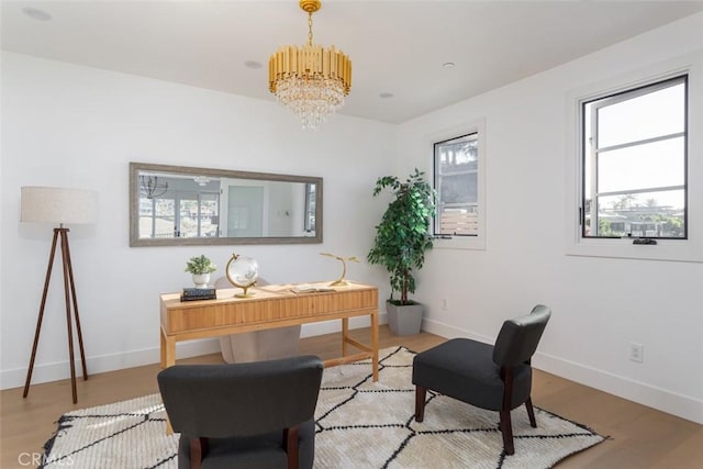 living area with light wood-type flooring and a chandelier