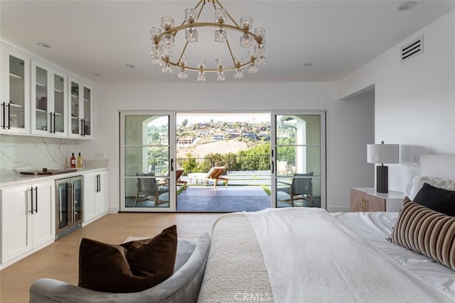 bedroom featuring a chandelier, access to outside, wine cooler, and light hardwood / wood-style floors