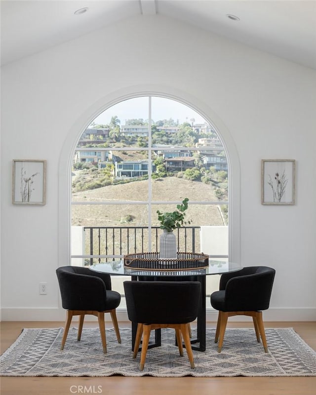 dining space featuring hardwood / wood-style floors and lofted ceiling with beams