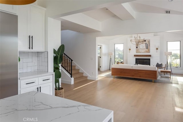 living room with plenty of natural light, lofted ceiling, and light wood-type flooring