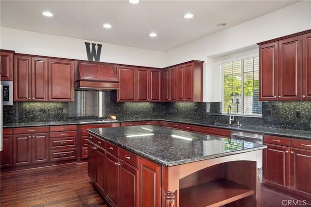 kitchen with custom exhaust hood, sink, decorative backsplash, a kitchen island, and dark hardwood / wood-style flooring