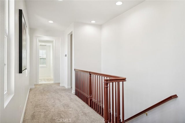 hall with light colored carpet