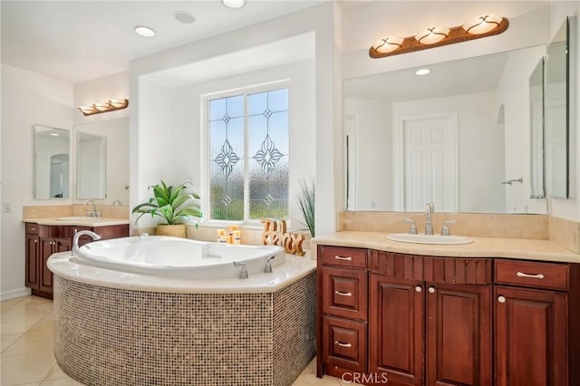 bathroom featuring tile patterned floors, a relaxing tiled tub, and vanity