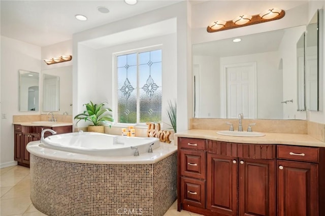 bathroom featuring a relaxing tiled tub, vanity, and tile patterned flooring