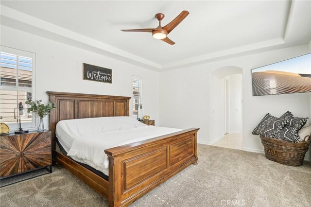 bedroom with ceiling fan, light colored carpet, and multiple windows