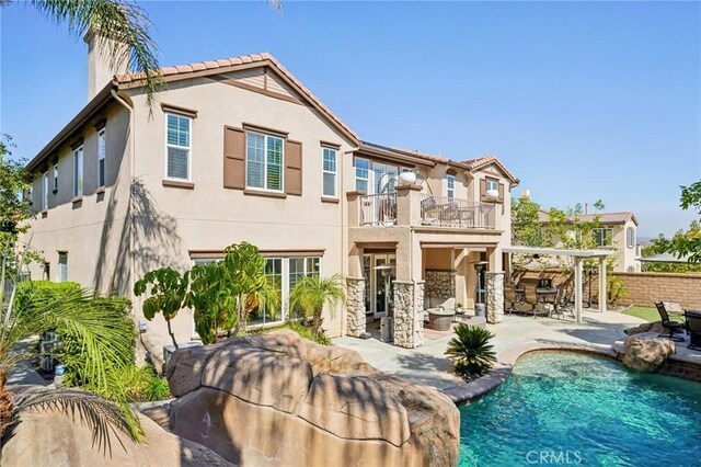 rear view of house with a patio area and a balcony