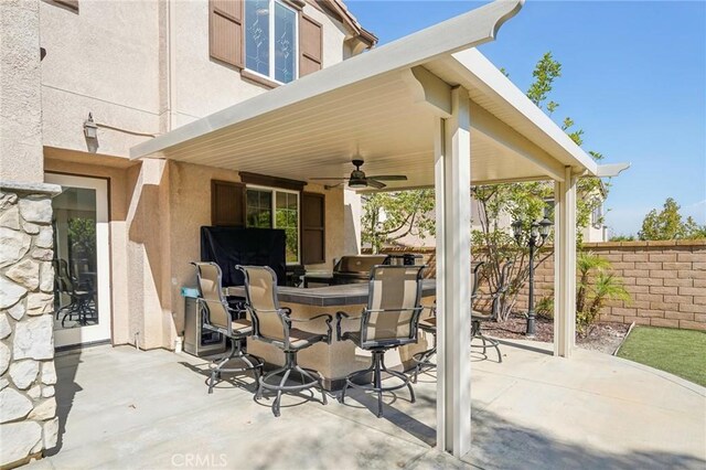 view of patio / terrace with an outdoor kitchen, an outdoor bar, and ceiling fan