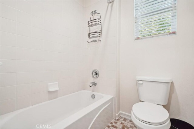 bathroom with tiled shower / bath combo and toilet