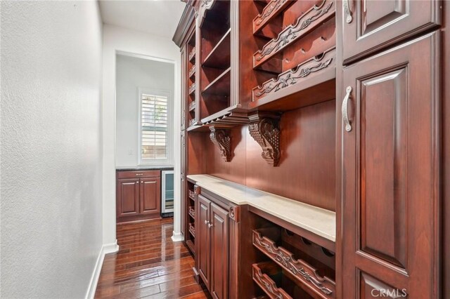 bar featuring dark hardwood / wood-style floors and beverage cooler