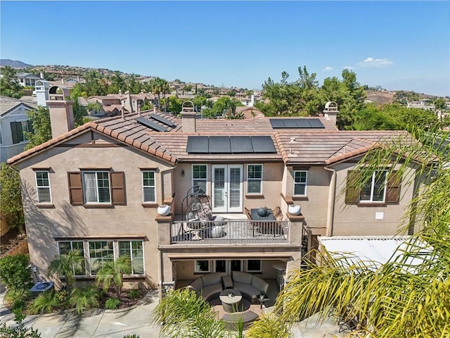 rear view of property with a balcony and an outdoor living space