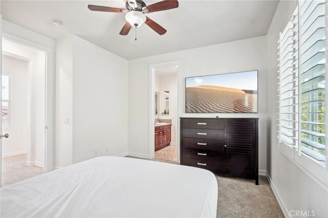 bedroom with ensuite bathroom, sink, ceiling fan, and light colored carpet