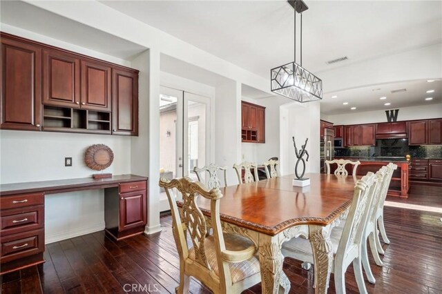 dining area with built in desk and dark hardwood / wood-style flooring